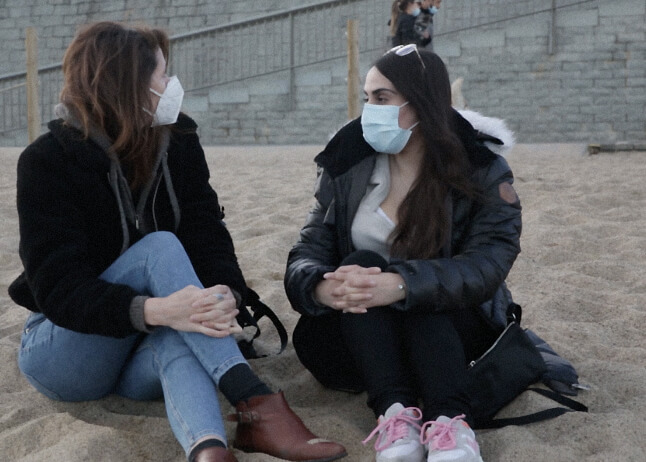 Iman and her friend sitting at the beach